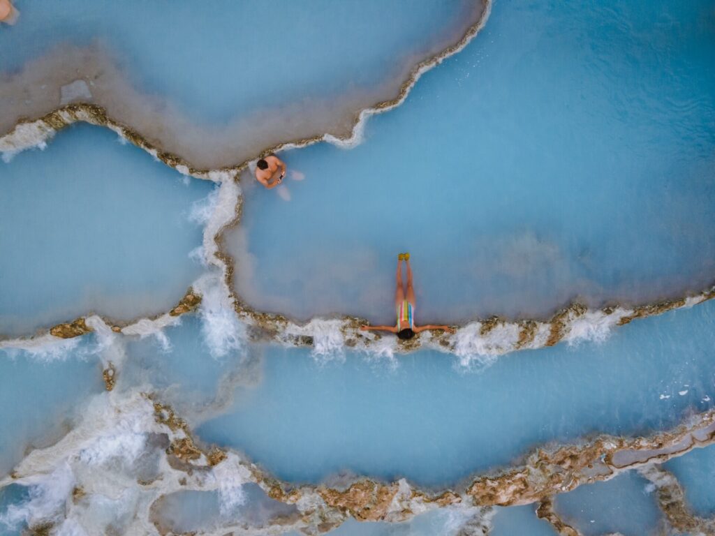 Toscane Italy, natural spa with waterfalls and hot springs at Saturnia thermal baths, Grosseto, Tuscany, Italy aerial view on the Natural thermal waterfalls couple at vacation at Saturnia Toscany