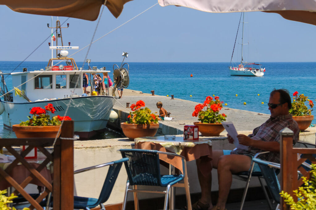 Marciana Marina, Italy - July 01, 2015: Tourist resting on the outdoor cafe on Elba island. Marciana Marina is  one of the most important towns of Elba Island in region of Tuscany, Italy