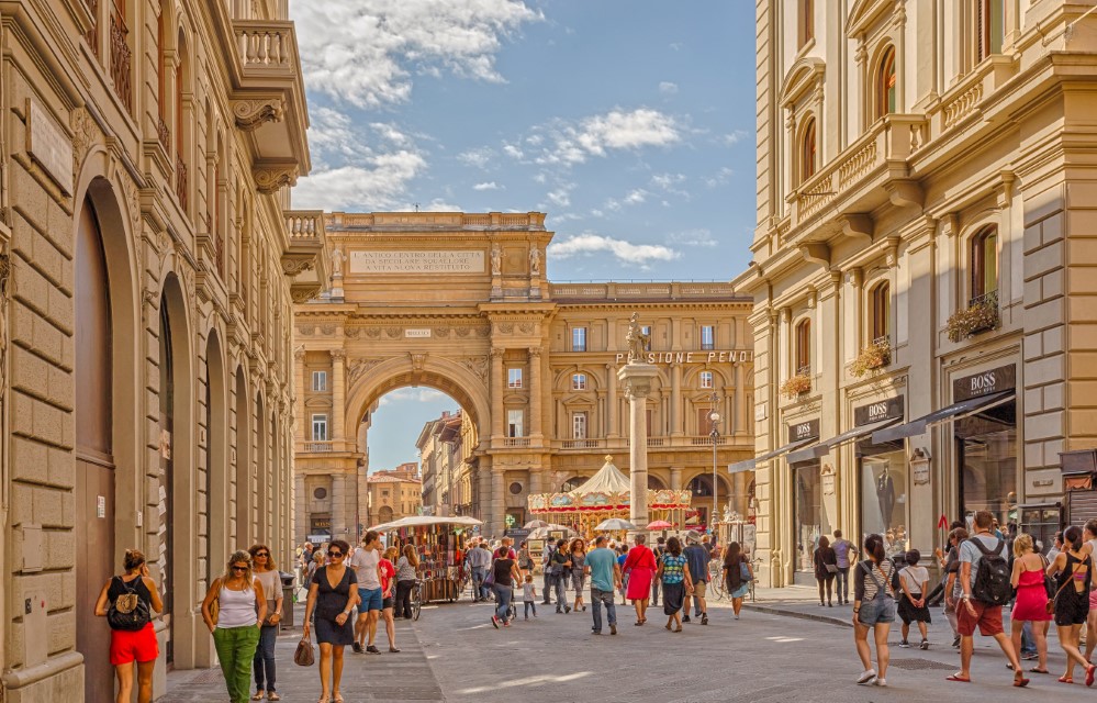 Florence, Italy - 14 September 2014: Florence, Italy - 14 September 2014: The street leading to the Arch in honor of King Victor Emmanuel and Pillar 2 of Plenty at the Republic Square in Florence. 
