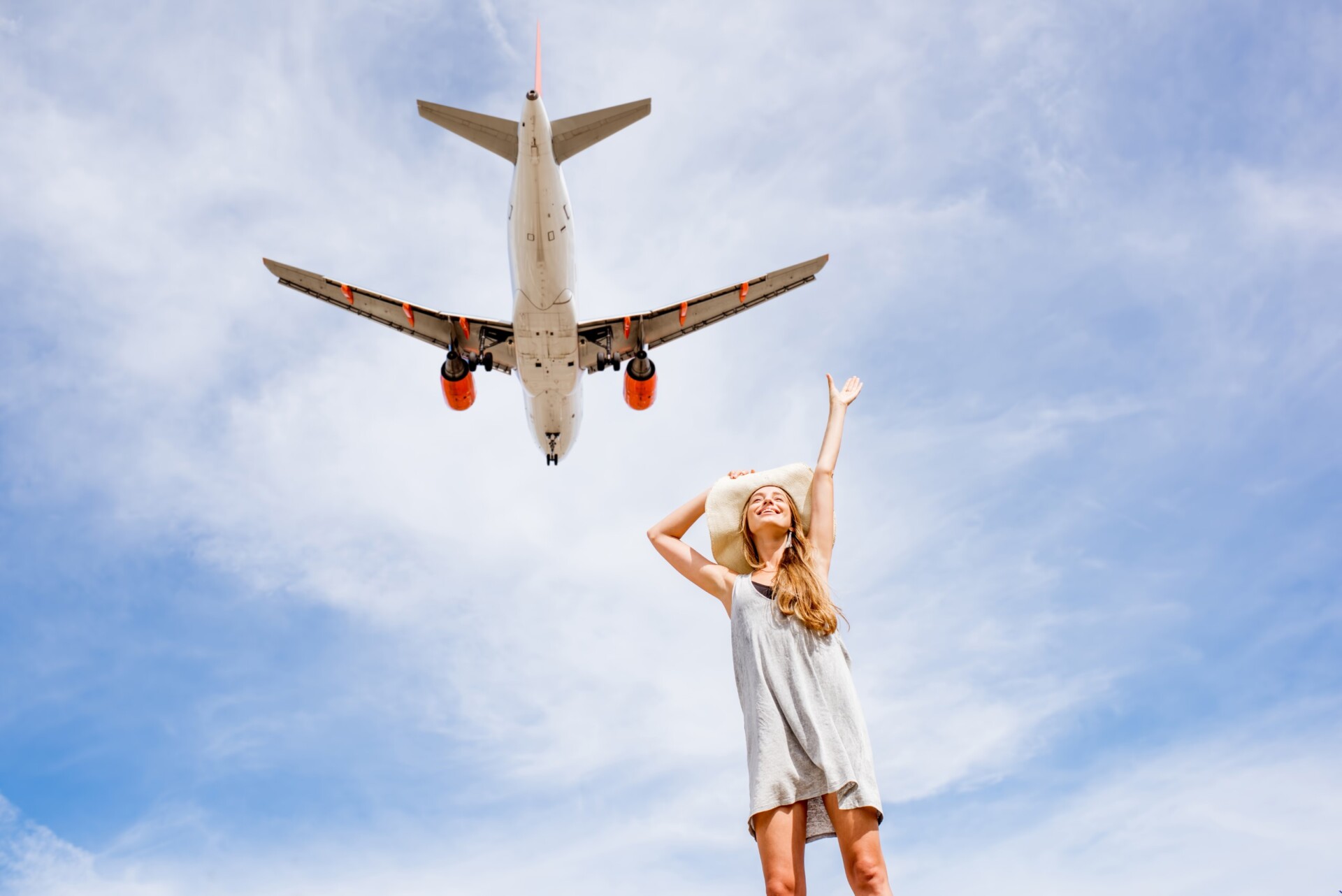 Young and happy woman enjoying the airplane flying in the sky